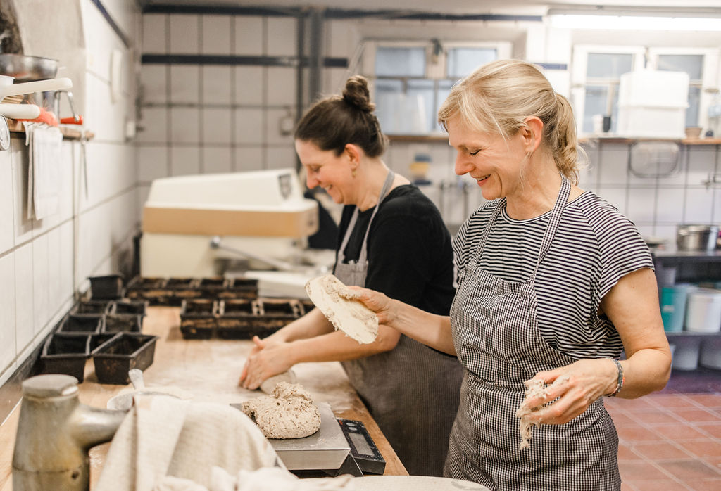 Zwei Bäckerinnen formen Teig am Arbeitstisch