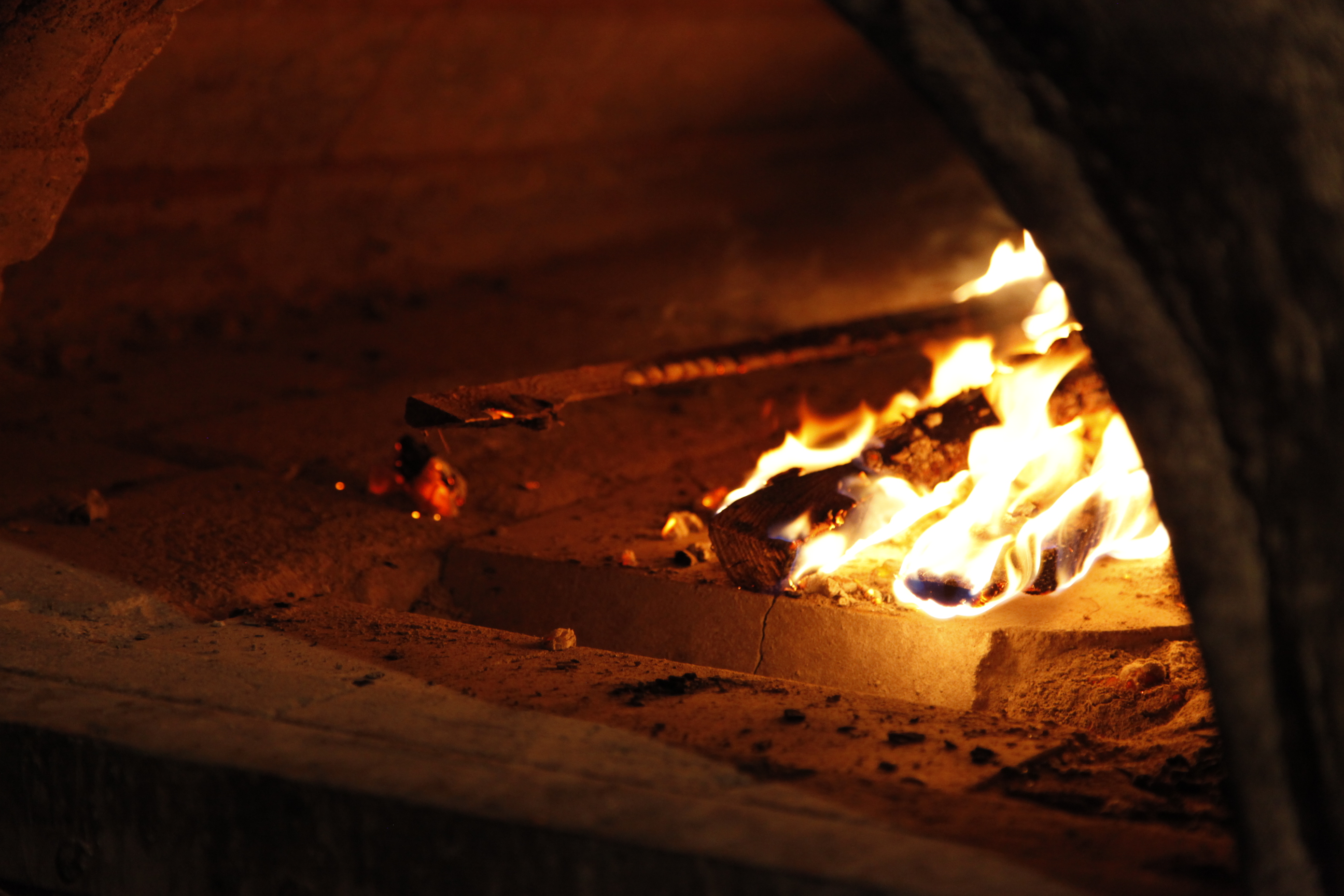 Feuer im offenen Holzofen der Backstube