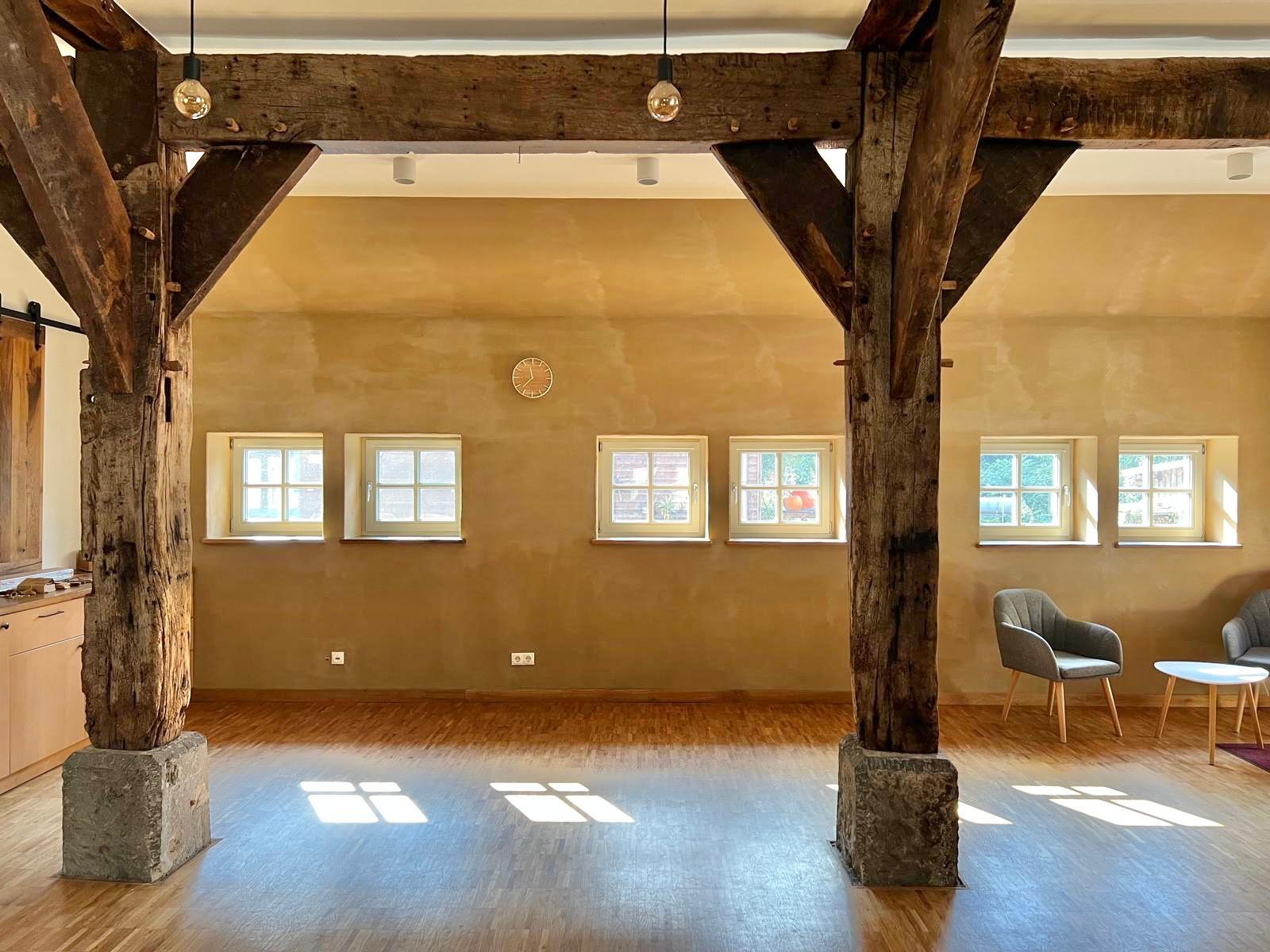 FarmRetreat – heller Seminarraum mit historischen Holzbalken und sonnendurchfluteten Fenstern