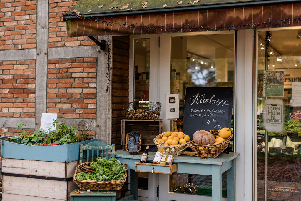Hofladen – Kürbisse auf dem blauen Tisch vor dem Eingang